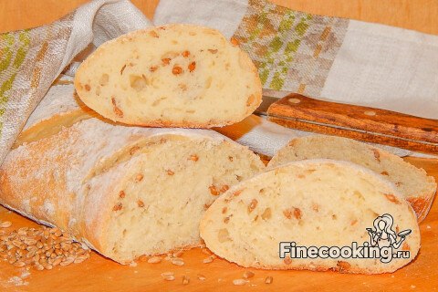 Ломоть хлеба с зёрнышками пшеницы и хрустящей корочкой на столе