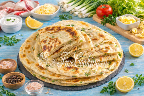 Готовое блюдо: Слоеные лепешки с зеленым луком на сковороде (постные) на тарелке